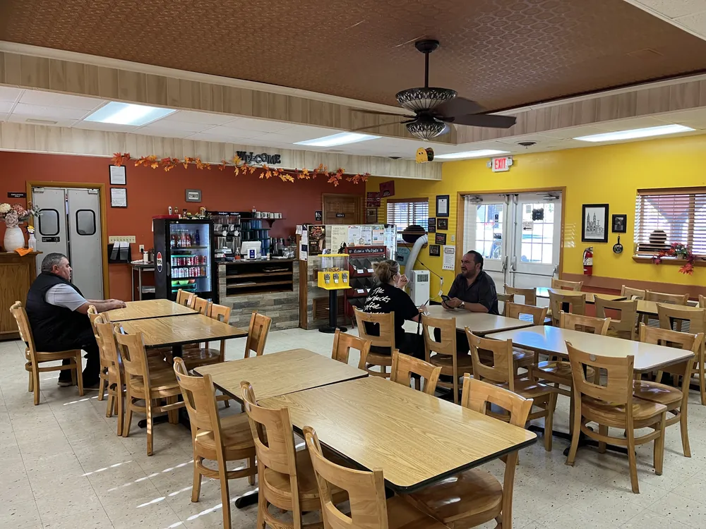 Lola's dining room with orange and yellow walls, wooden tables and guests talking