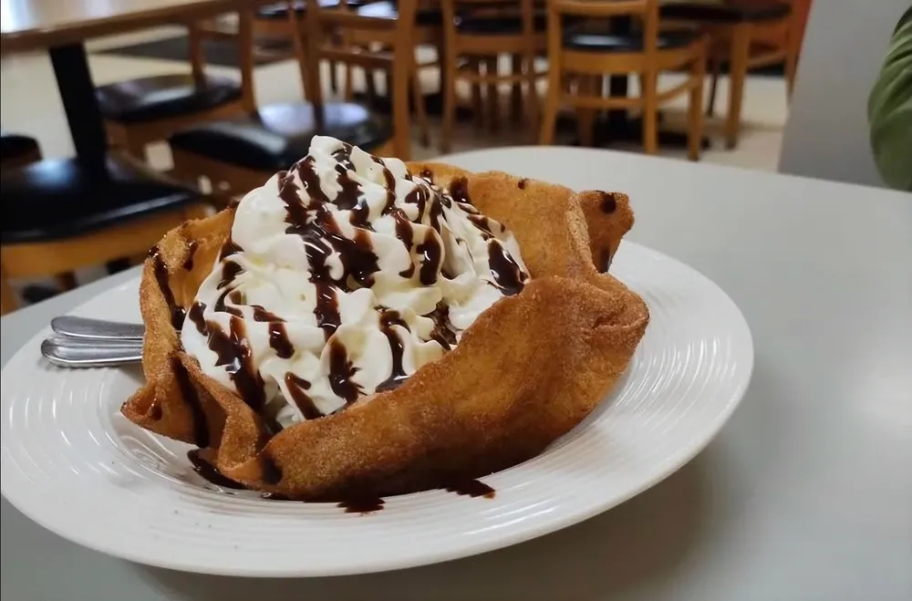 Fried ice cream in a cinnamon tortilla bowl with whipped cream and chocolate
